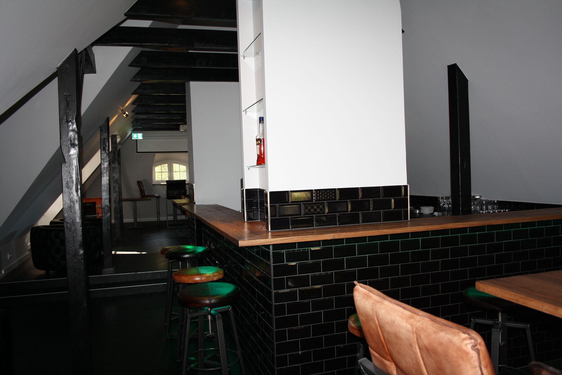 Ein Raum mit einer Bar und Hockern darin