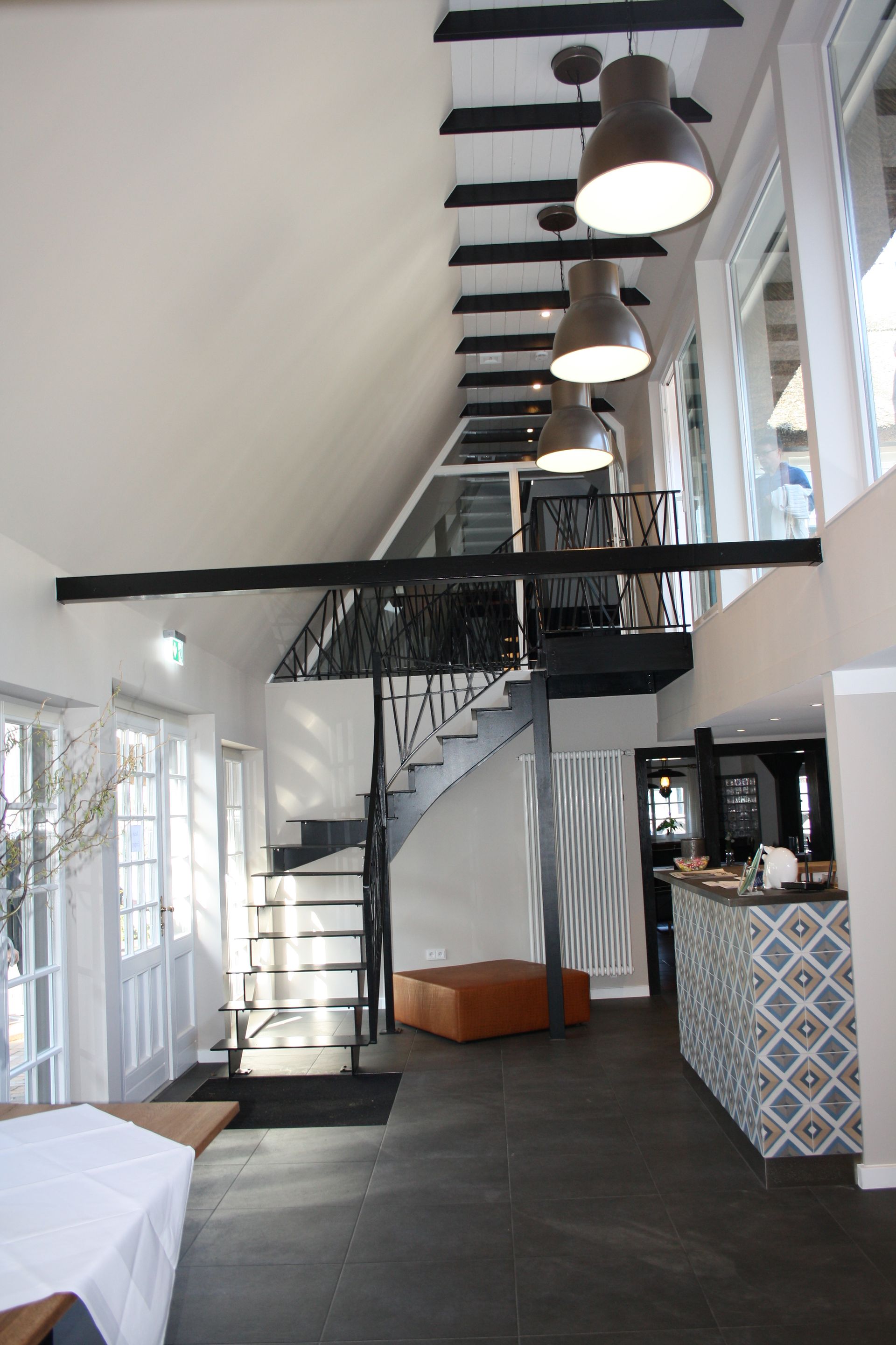 Ein Raum mit einer Treppe und vielen Fenstern