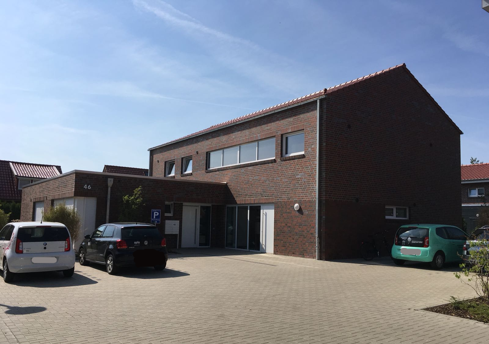 Ein Backsteingebäude mit davor geparkten Autos
