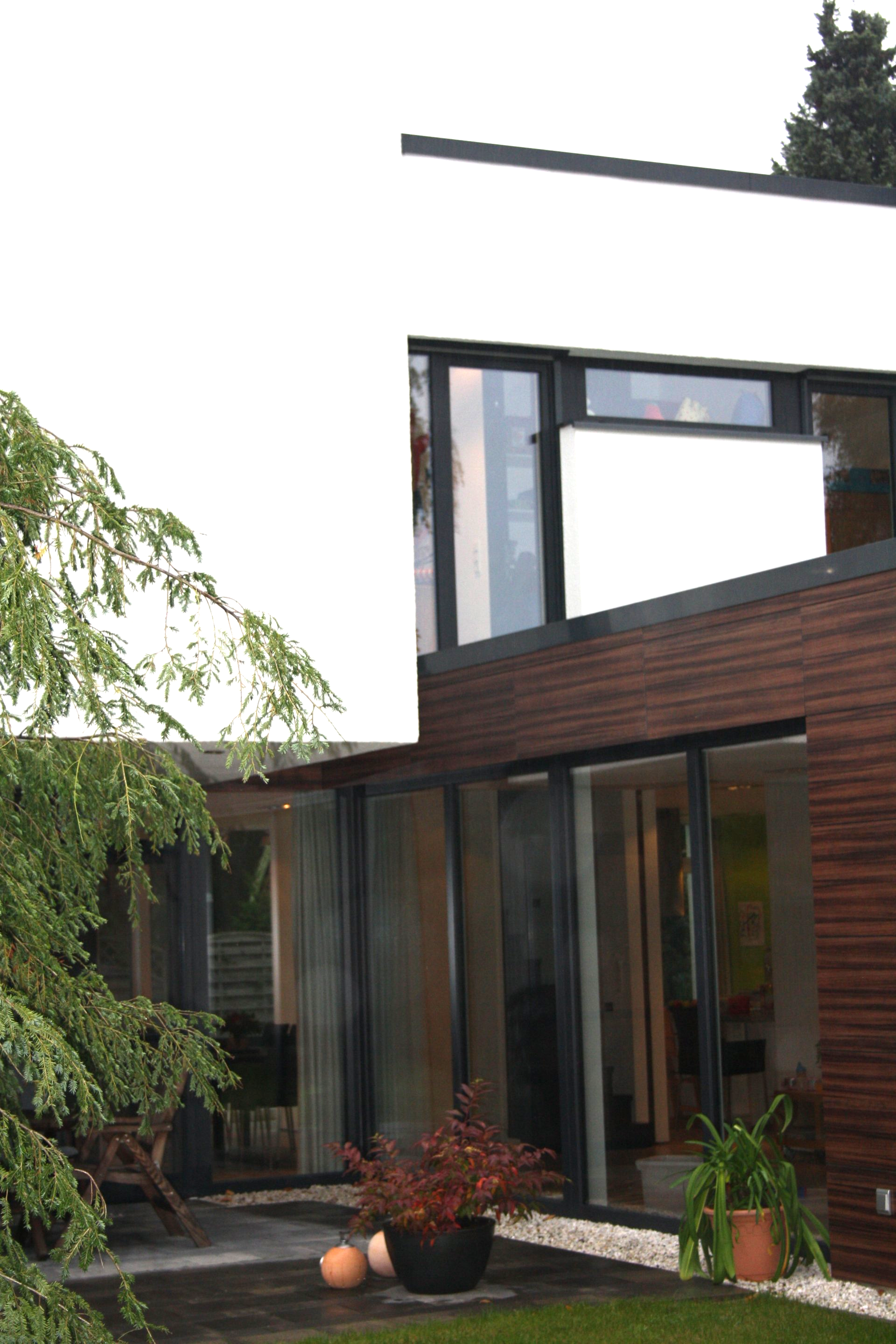 Ein Haus mit vielen Fenstern und einem Baum davor