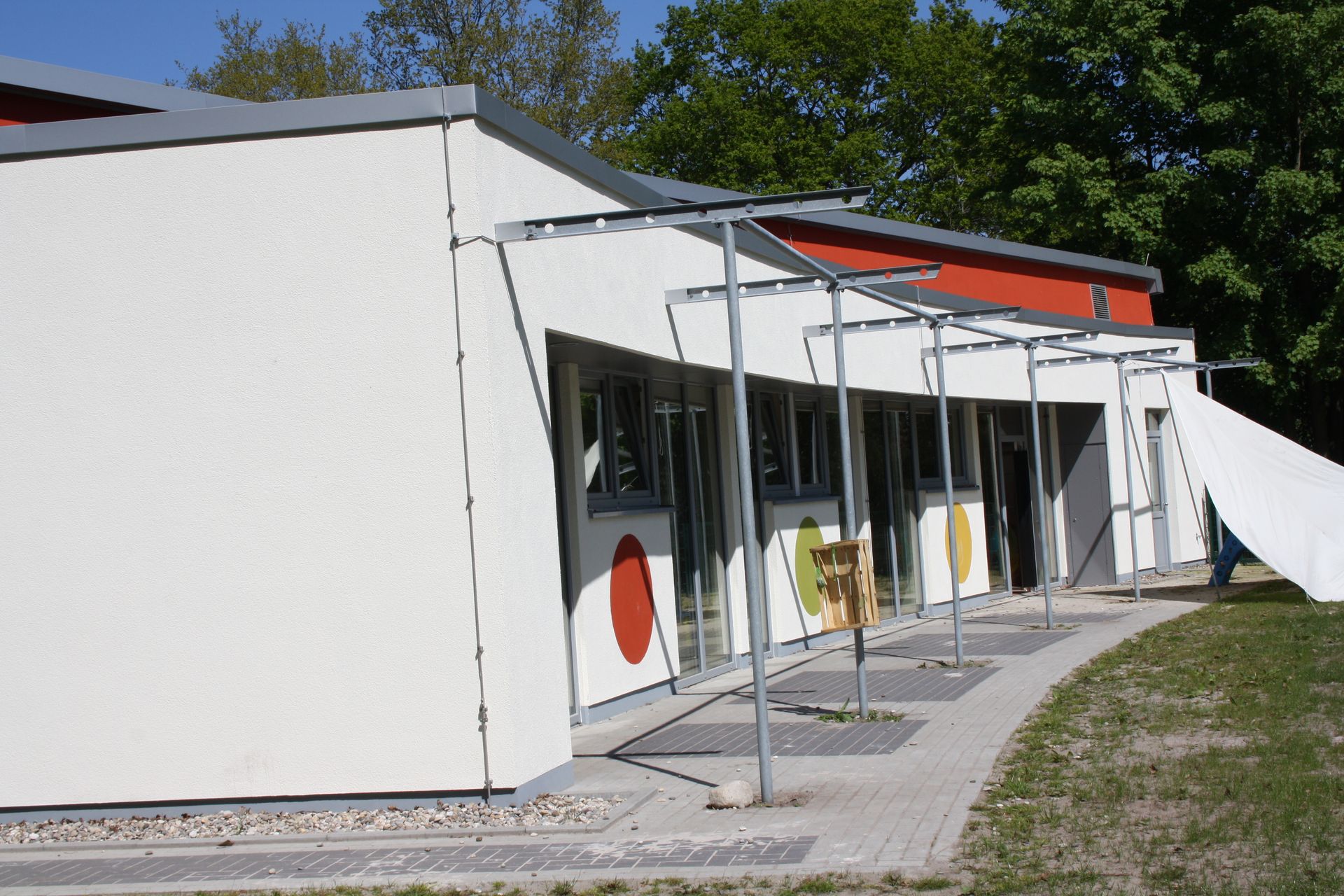 Ein weißes Gebäude mit einem roten Dach ist von Bäumen umgeben