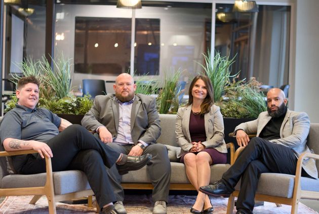 A group of people are sitting on a couch in a living room.