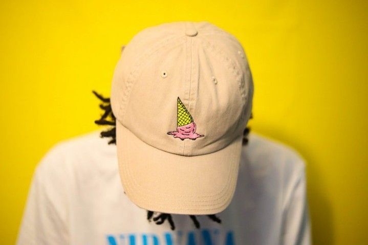 A person wearing a baseball cap with an ice cream cone on it
