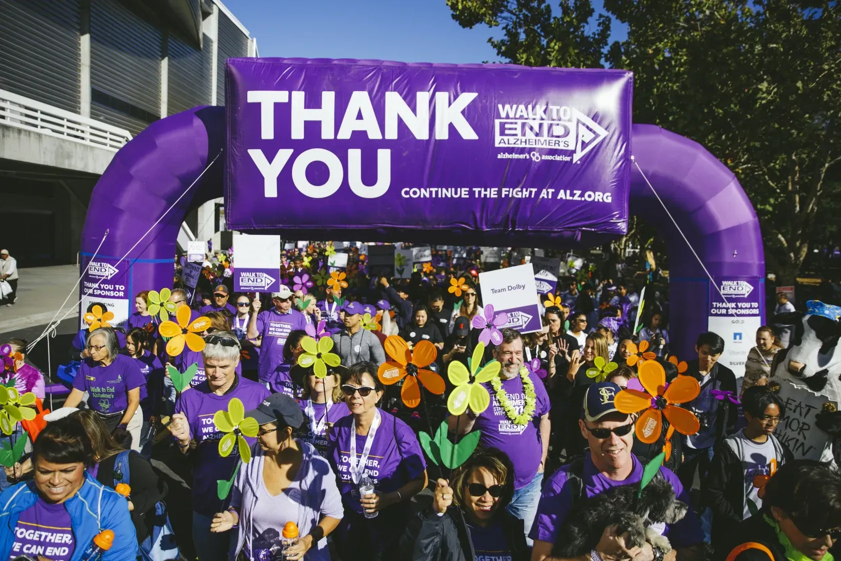 A group of people are walking under a thank you sign