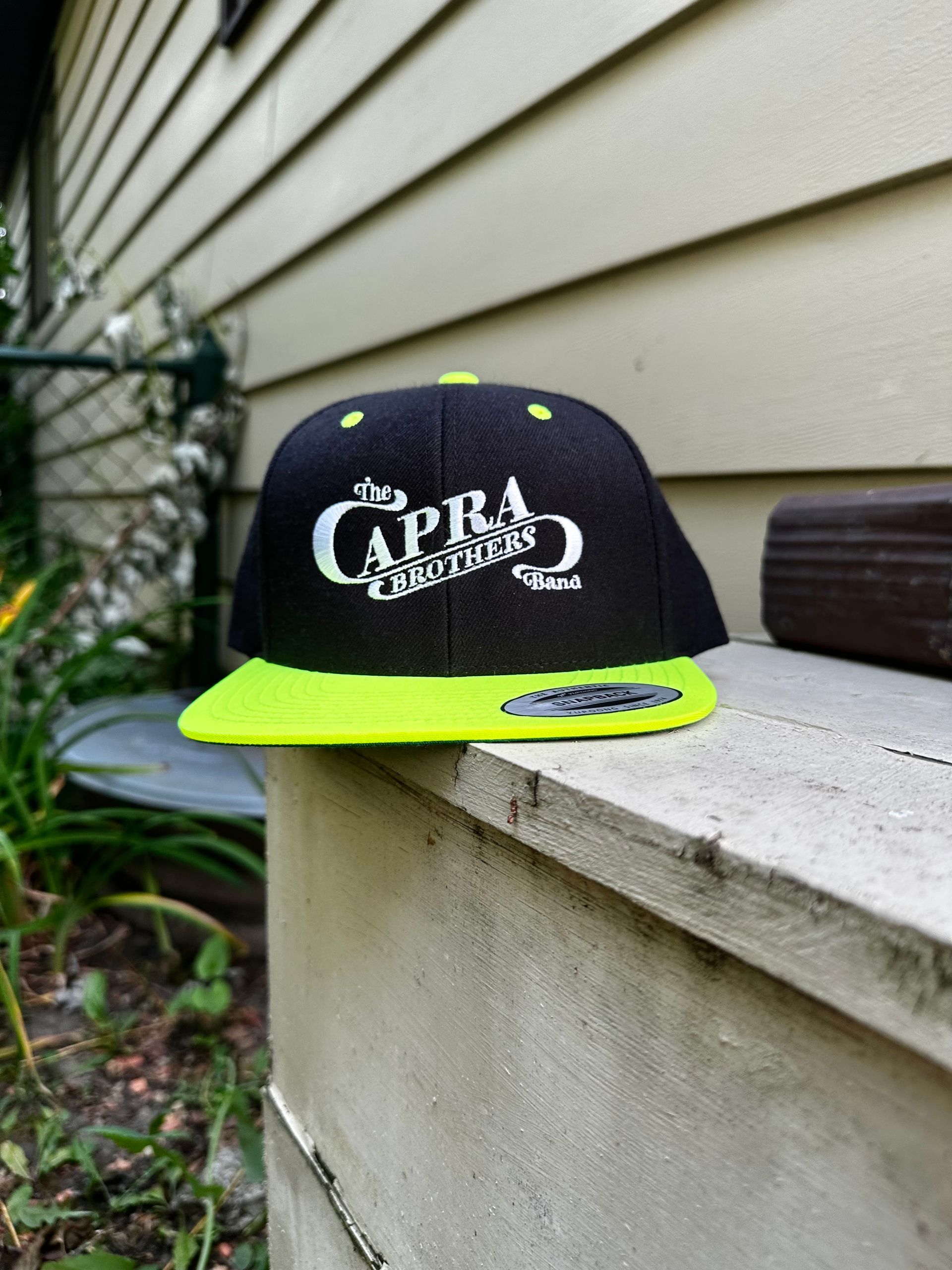 A black and yellow cap with the word capri on it