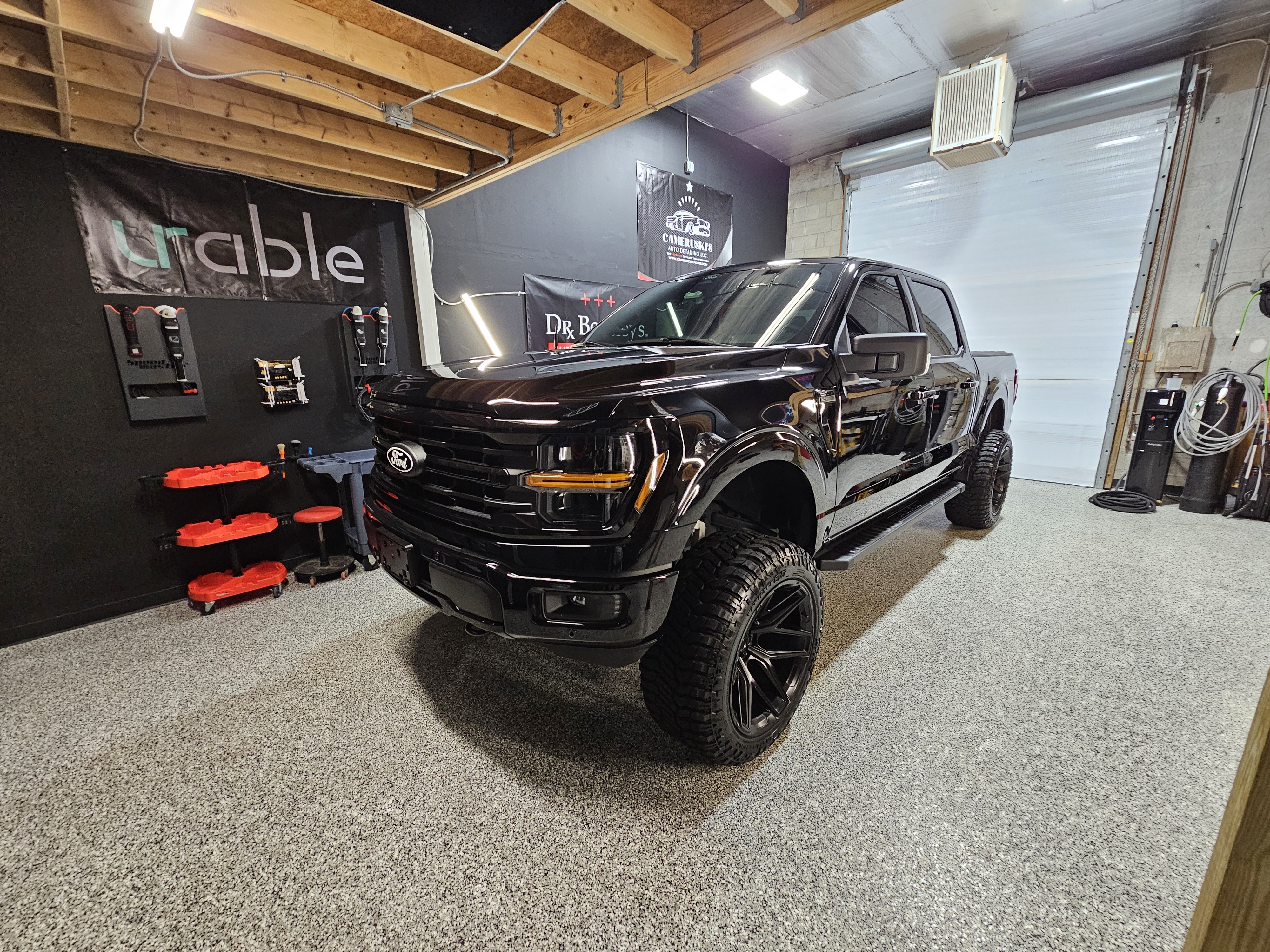A black and yellow sports car is parked in a garage.