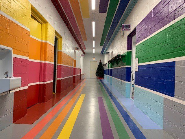 Colorful hallway with rainbow painted walls and floor.