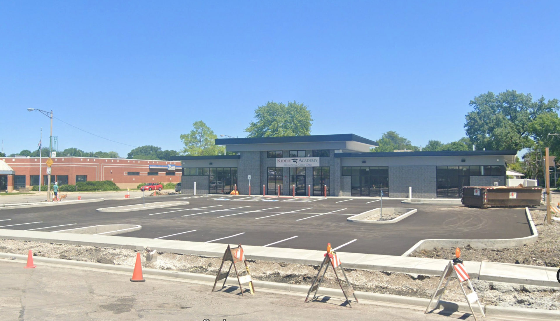 New gas station with unfinished parking lot under construction on a sunny day.