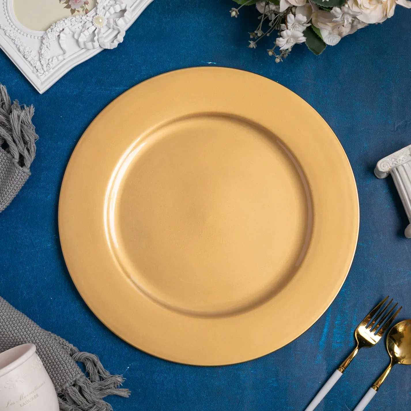 Gold-toned round plate or charger viewed from above on a white background