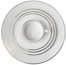 White teacup on stacked white saucers, viewed from above.