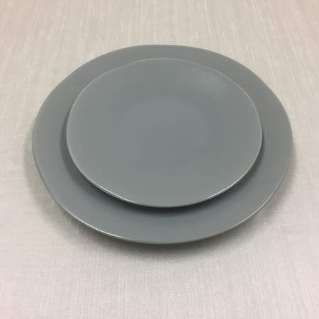 Stacked white plates and a bowl on a white background