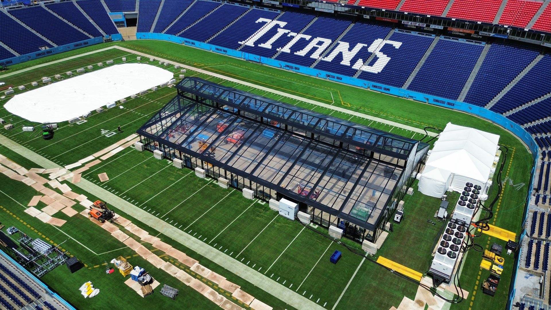 Aerial view of a football stadium under construction, with Titans seating visible in the stands.