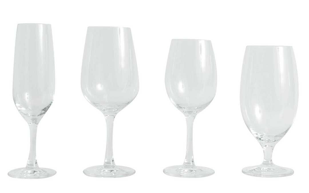 Four clear wine glasses of varying shapes lined up on a white background.