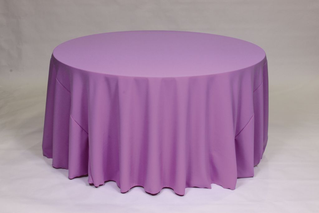 Round table with a white floor-length tablecloth on a plain light background