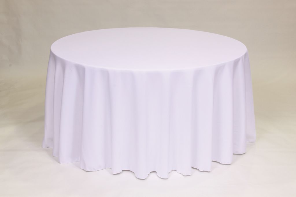 Round table with a white floor-length tablecloth on a plain light background