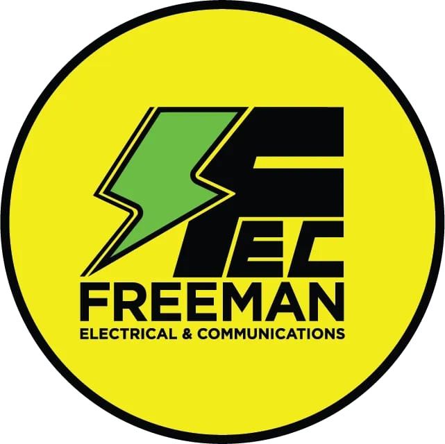 Yellow circular logo for Freeman Electrical & Communications with green lightning bolt and black “FEC” text