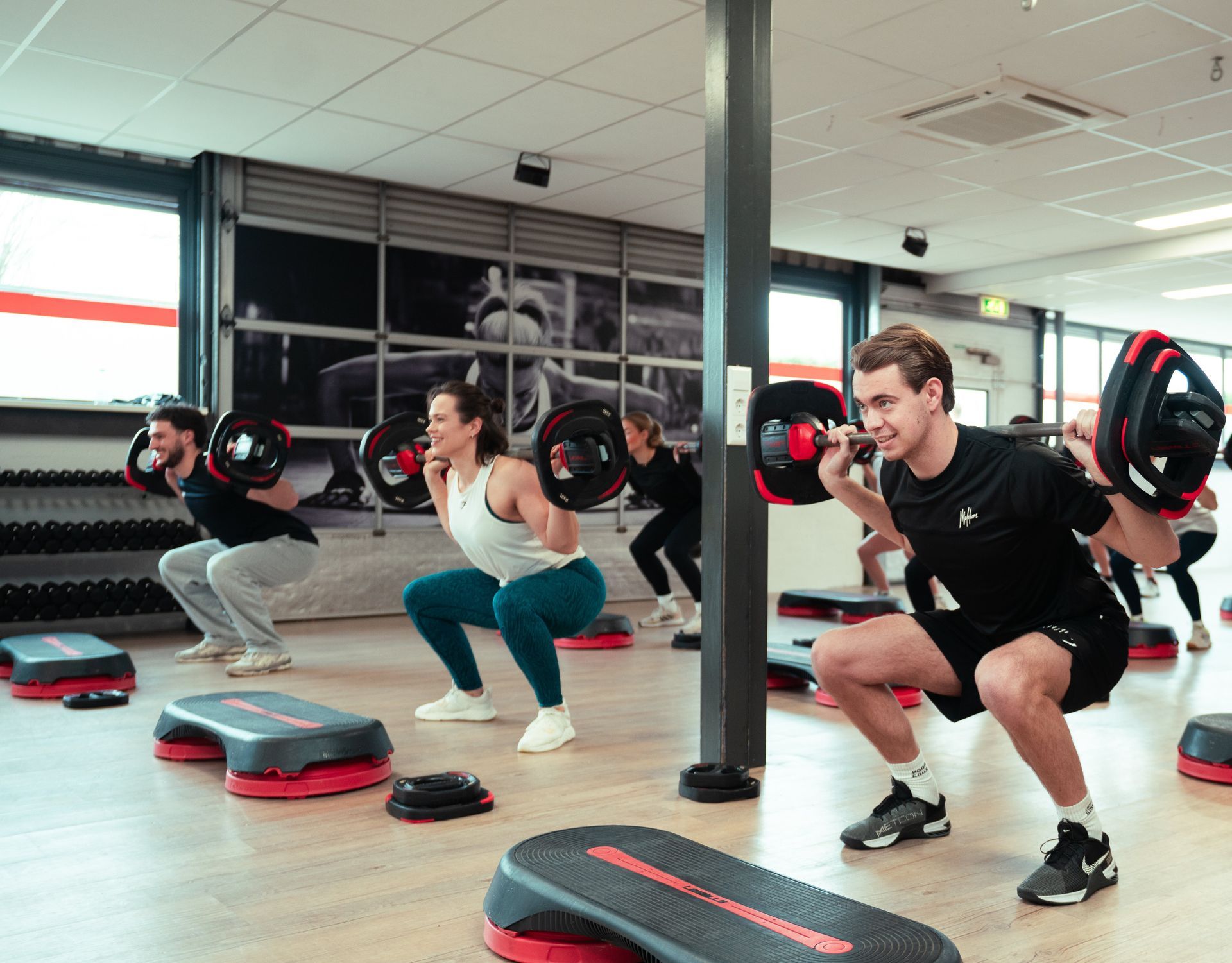 een groep mensen doet oefeningen in een sportschool.