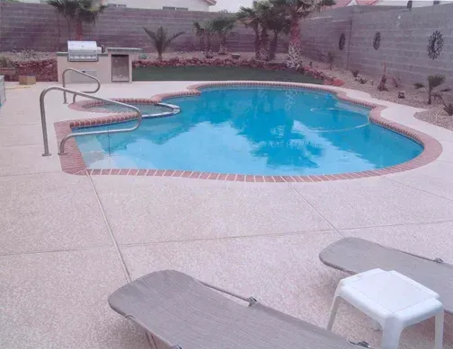 Swimming pool with brick border, patio, lounge chairs, and an outdoor kitchen. Swimming pool with brick border, patio, lounge chairs, and an outdoor kitchen.