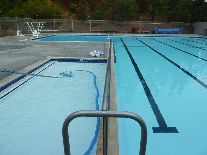 Swimming pools with blue water and diving board; exterior shot. Swimming pools with blue water and diving board; exterior shot.