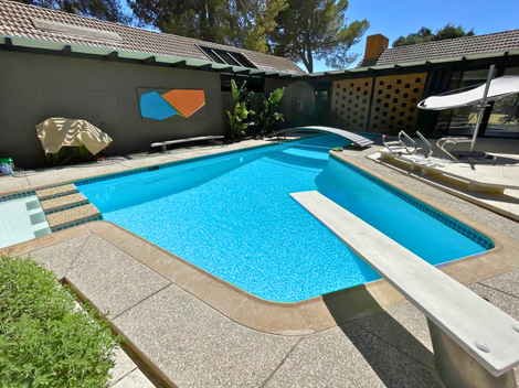 Rectangular pool covered with a white tarp, surrounded by concrete and grass, outdoors. Rectangular pool covered with a white tarp, surrounded by concrete and grass, outdoors.