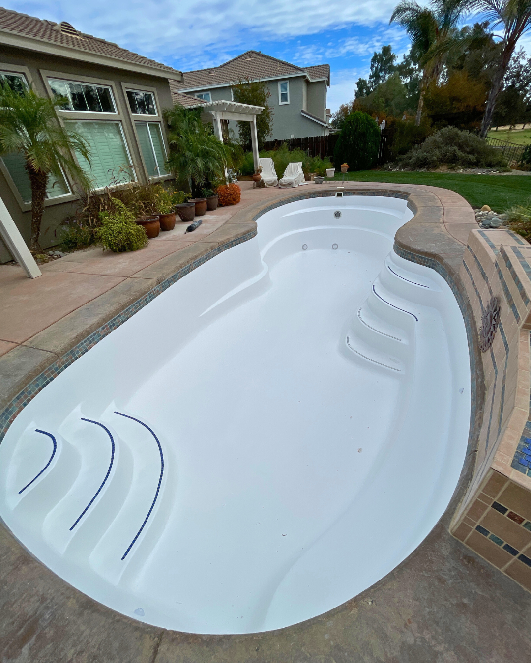 A fiberglass coated plaster pool full of water. A fiberglass coated plaster pool full of water.