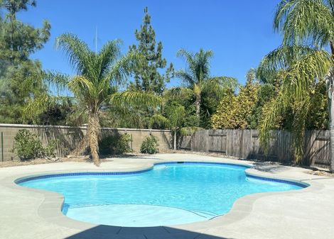 A fiberglass coated plaster pool full of water. A fiberglass coated plaster pool full of water.