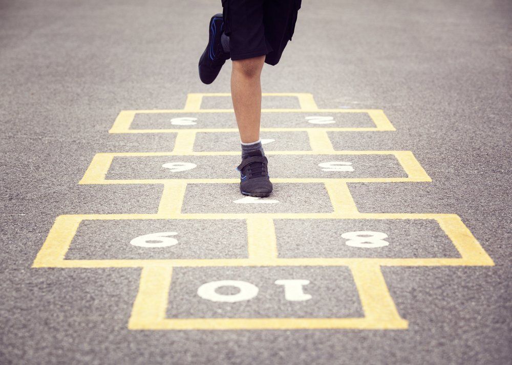 Child Playing Hopscotch on School Playground — Professional Concreting in Sunshine Coast, QLD