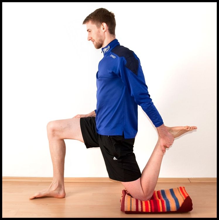 A Man in a Blue Shirt is Stretching His Leg — Anderson Family Chiropractic Health Centre in Mount Pleasant, QLD