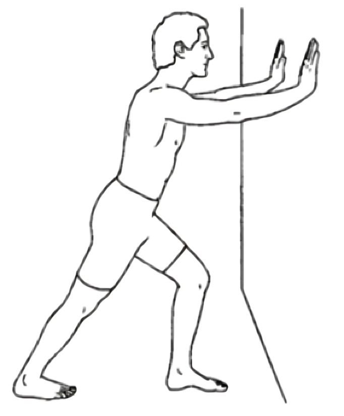 A Man Stretching His Legs Against a Wall — Anderson Family Chiropractic Health Centre in Mount Pleasant, QLD
