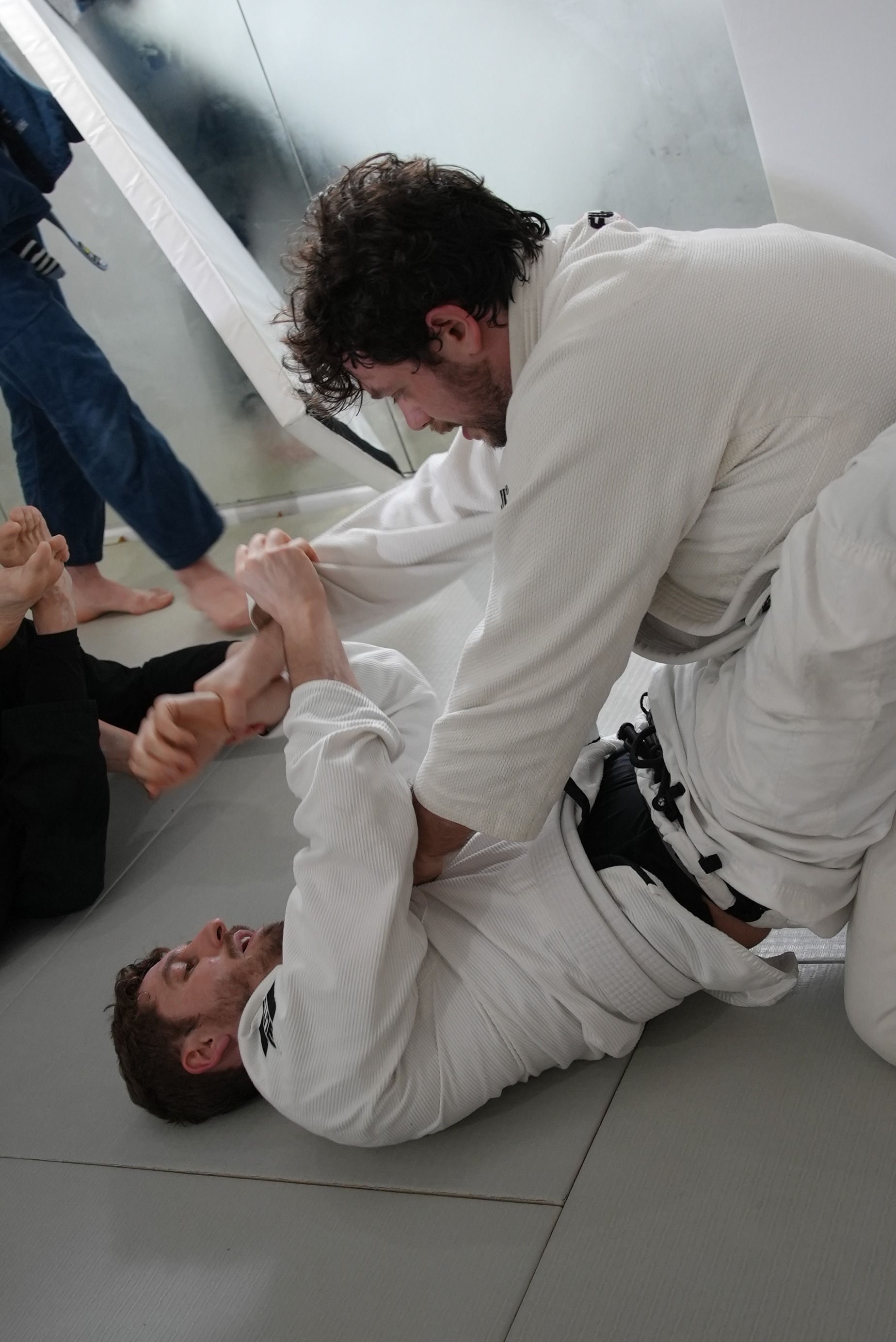 Adults drilling Brazilian Jiu-Jitsu guard passes at Range Brazilian Jiu-Jitsu NYC in New York for fitness and control.