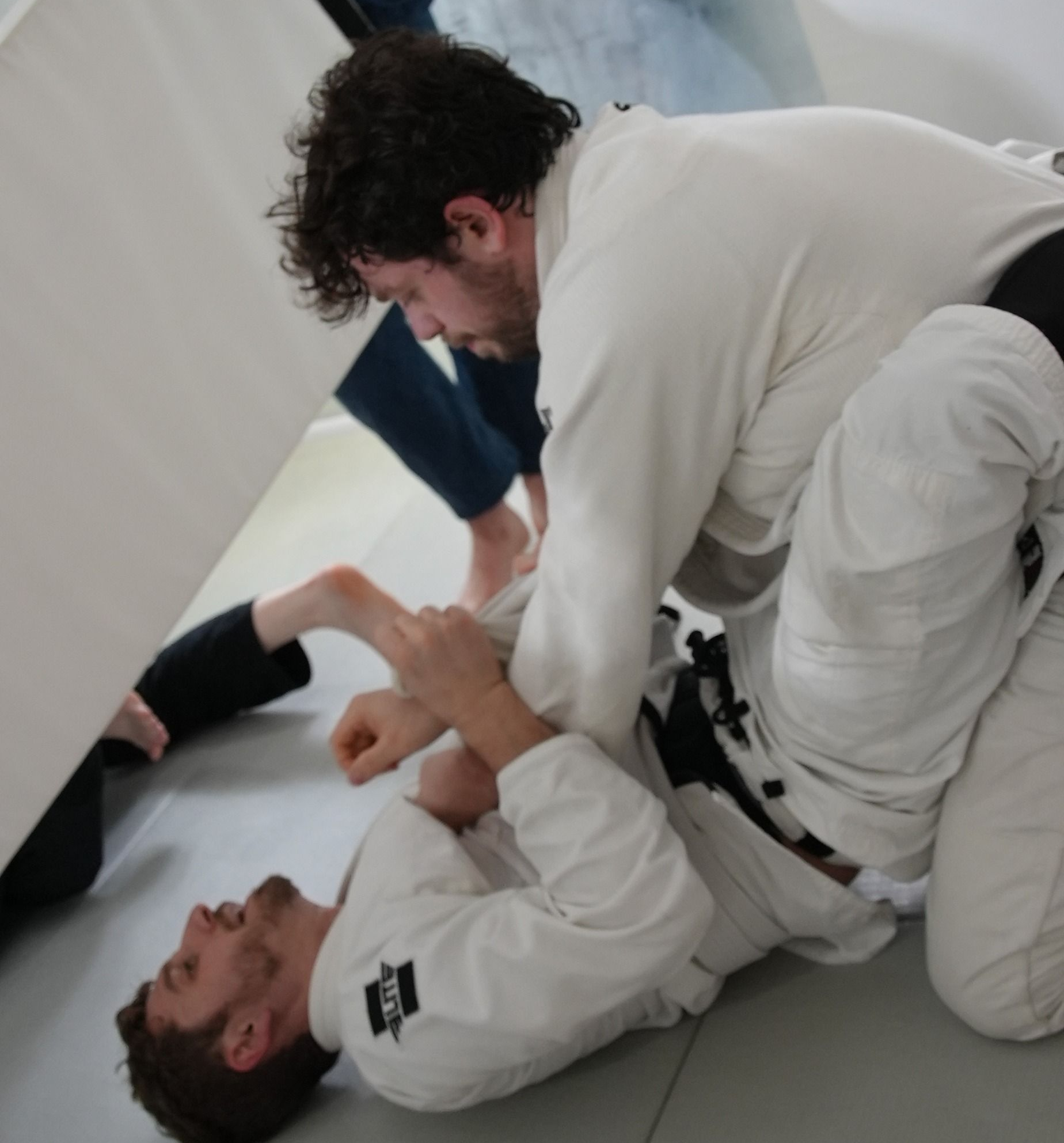 Adults practicing Brazilian Jiu-Jitsu sparring at Range Brazilian Jiu-Jitsu NYC in New York, NY.
