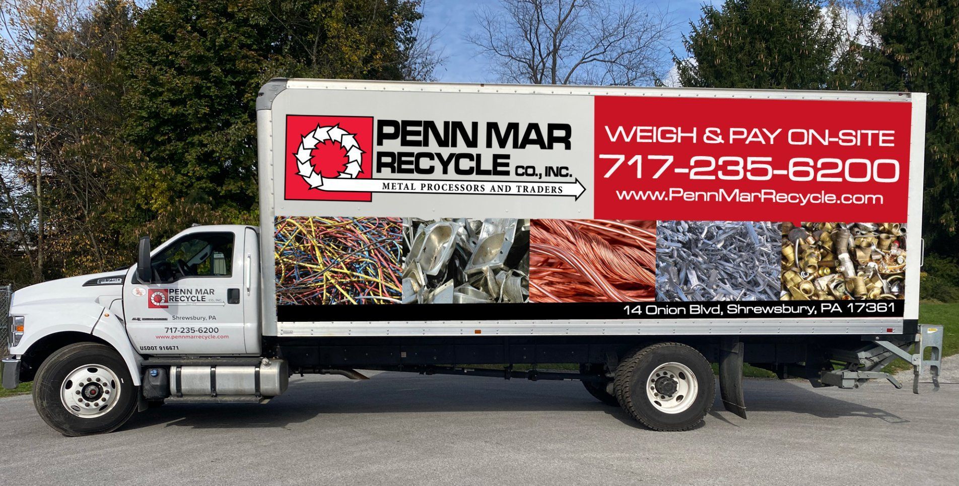 A white Penn Mar Recycle box truck parked outdoors, featuring contact info and imagery of various scrap metal materials.