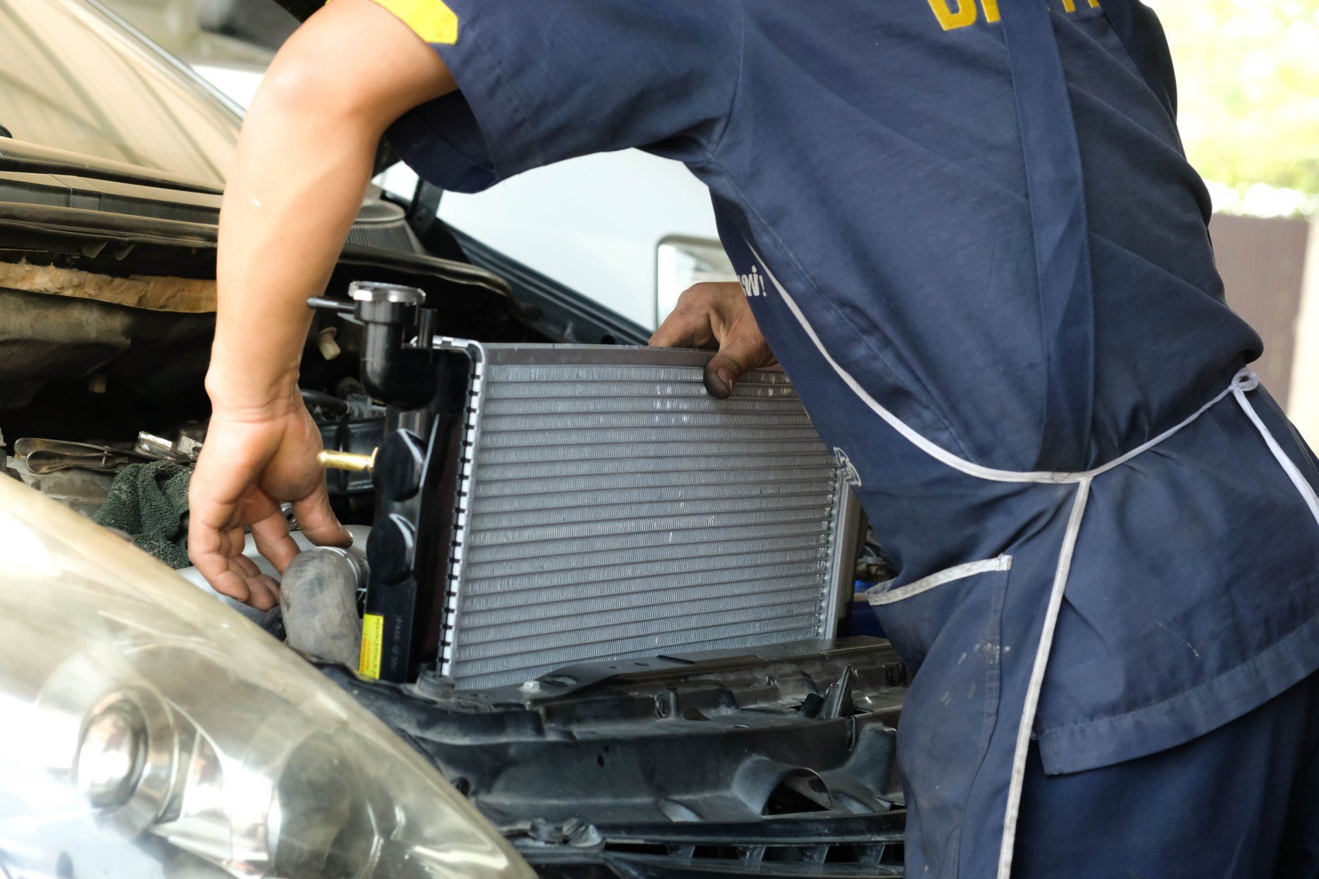 Un homme travaille sur le radiateur d'une voiture