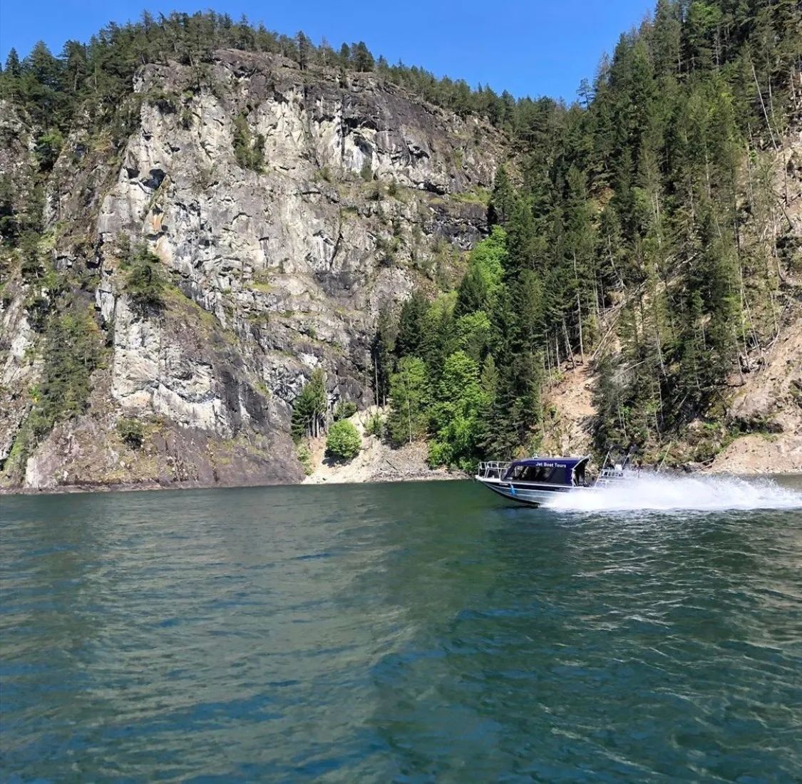 A boat is floating on a lake with a mountain in the background