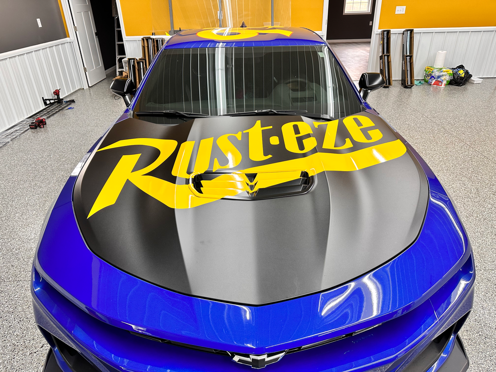 A blue car with the word rusteze on the hood