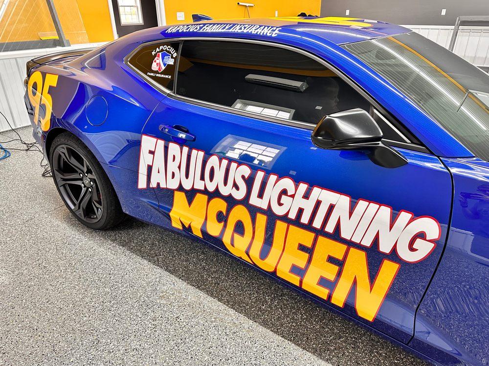 A blue car with fabulous lightning mcqueen written on it