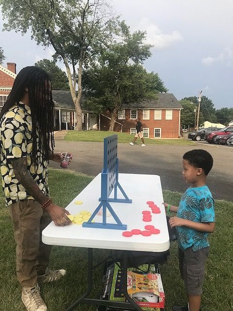 A man and a boy are playing a game on a table at a LCRC community event.