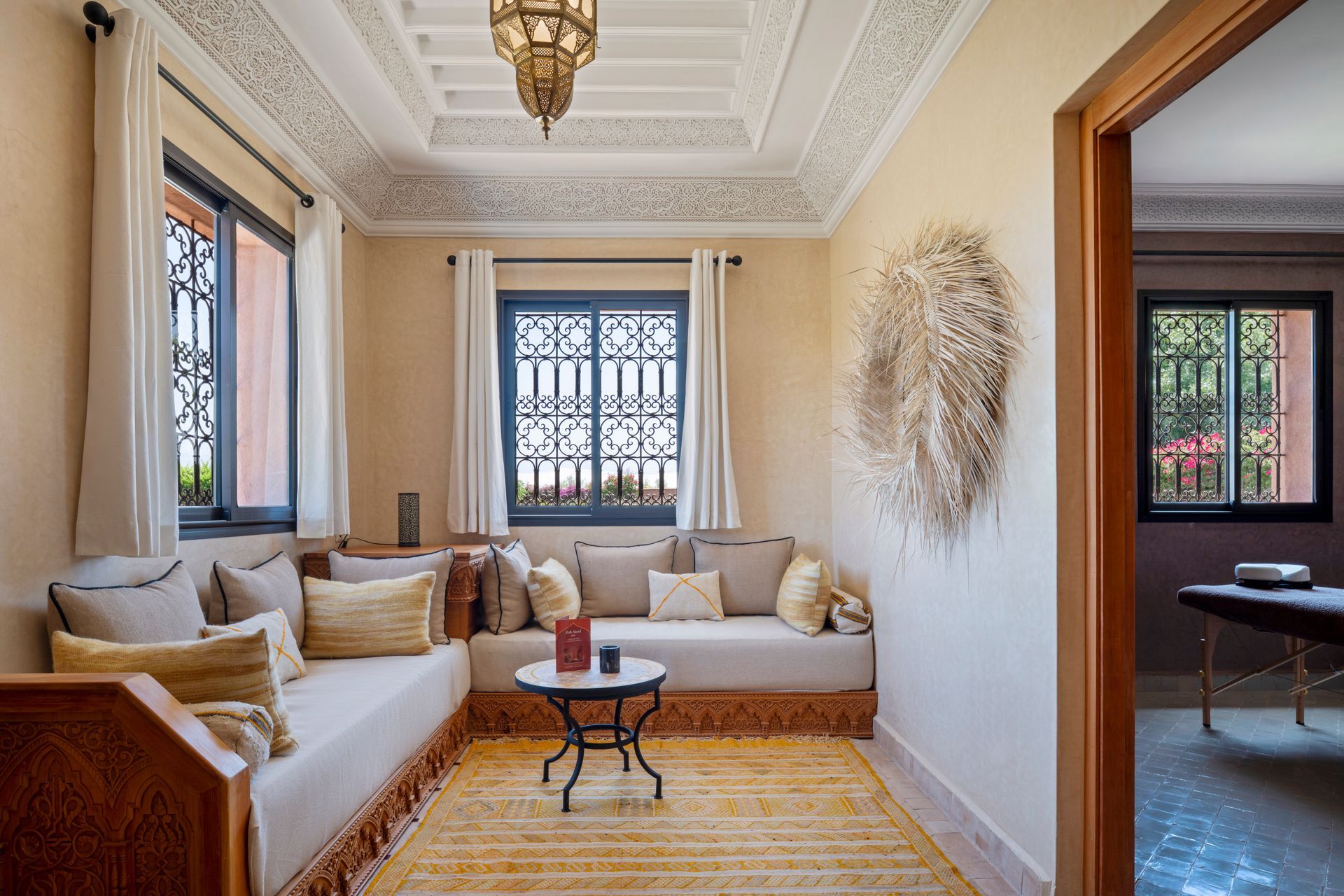 Elegant cream living room with sofa, patterned rug, coffee table, and ornate ceiling details