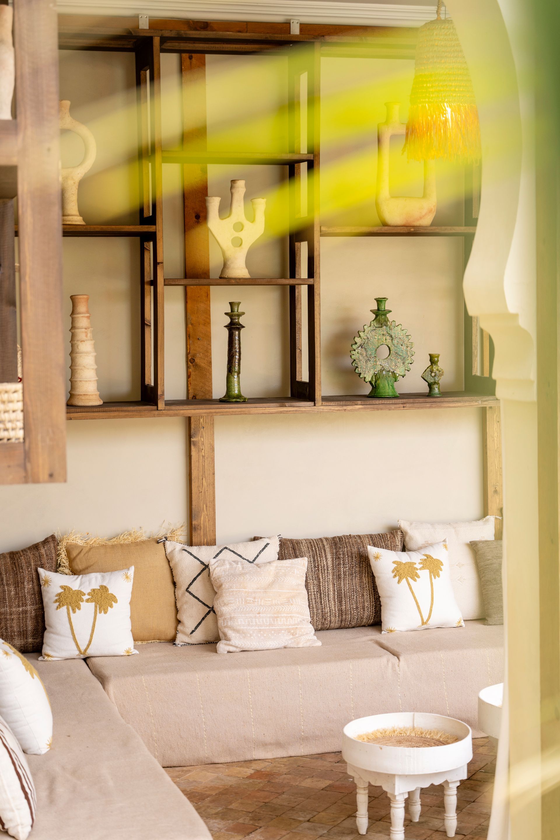 Cozy beige living room with built-in shelves, patterned pillows, and a small round white table