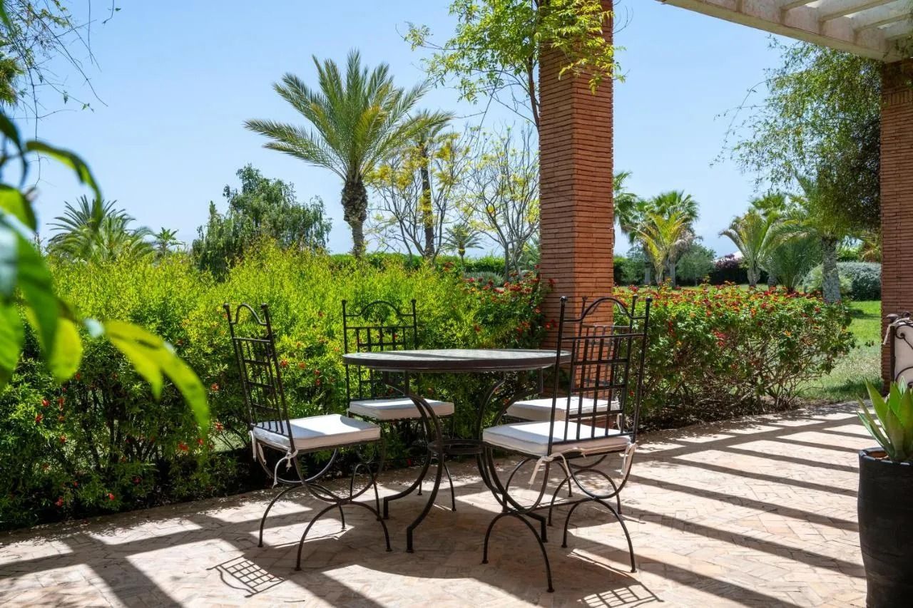 Tables dressées sous les arbres à Bab Akoul Atlas, lieu de mariage près de Marrakech