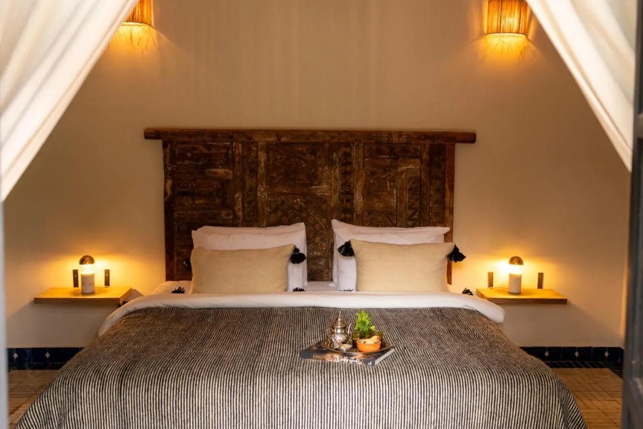 Cozy bedroom with a large bed, warm bedside lamps, and white draped curtains