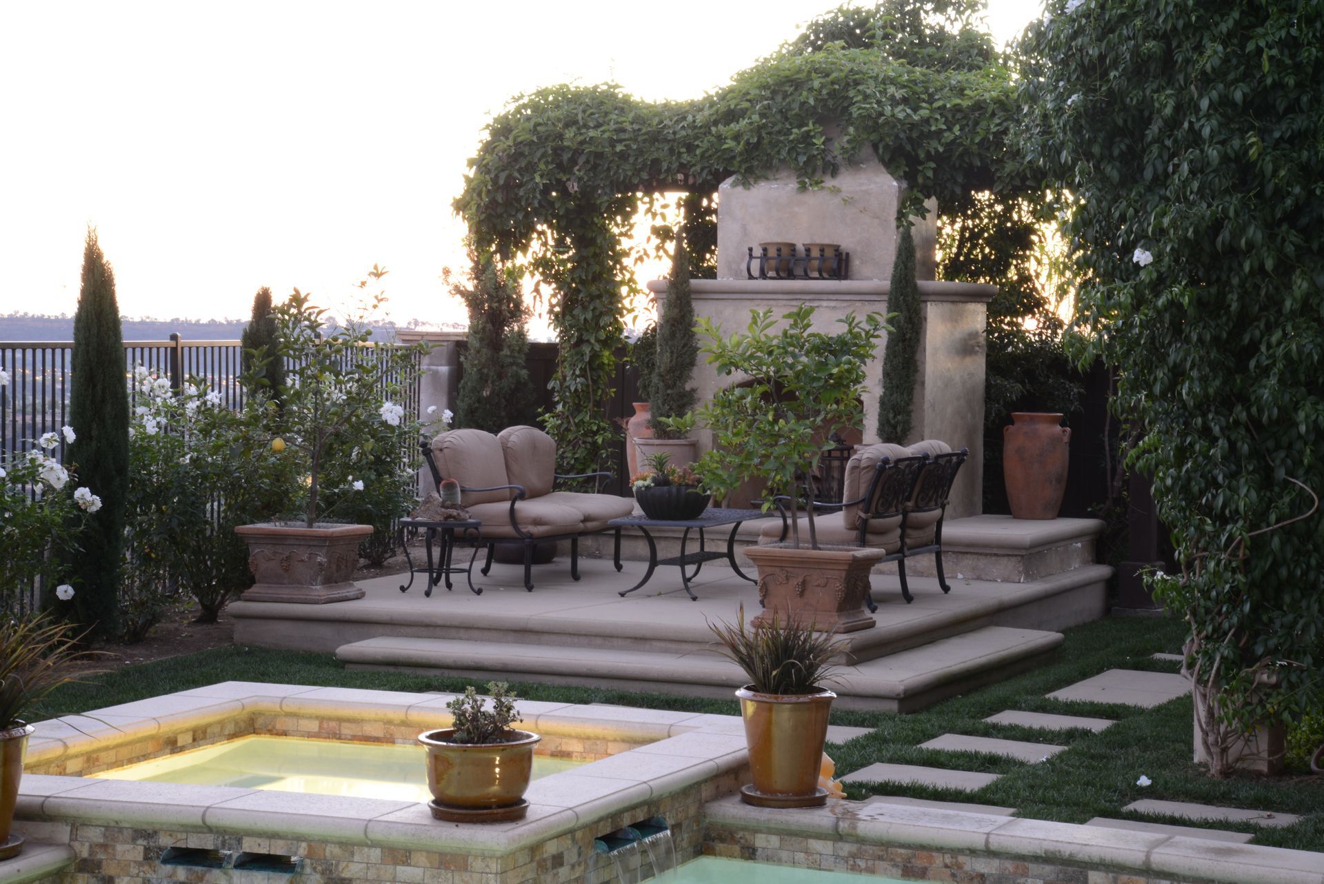 A patio area with a hot tub and a fireplace