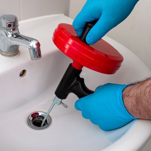 Plumber Cleaning a Sink Drain