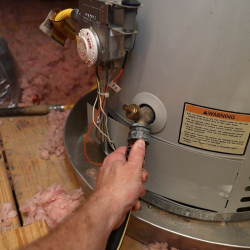 Plumber Fixing a Water Boiler Plumber Fixing a Water Boiler
