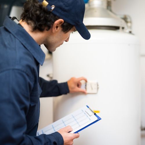 Plumber Doing Water Boiler Maintenance Plumber Doing Water Boiler Maintenance