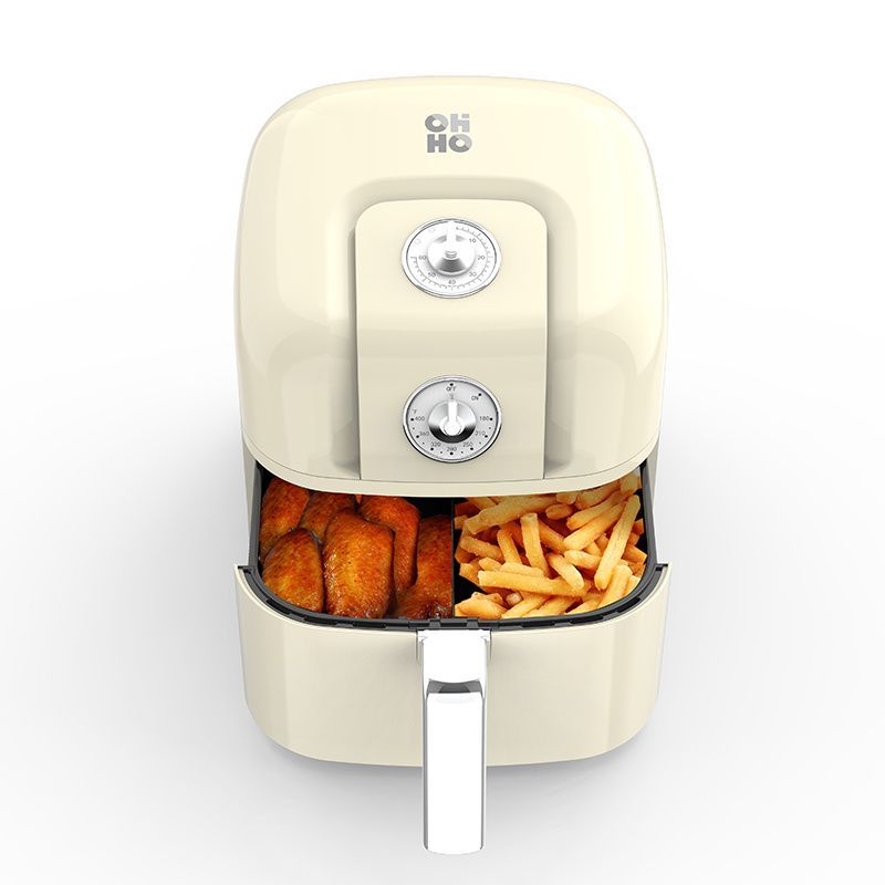 A cream-colored air fryer with an open drawer containing cooked chicken wings and french fries.