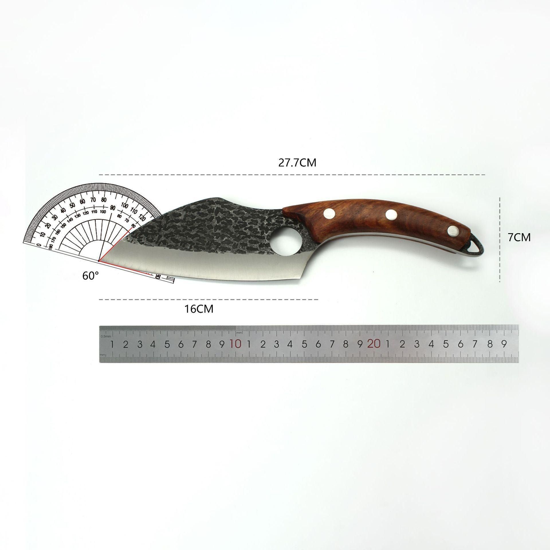 A forged, hole-blade knife with a wooden handle rests on a wooden surface next to raw meat and sliced ginger.