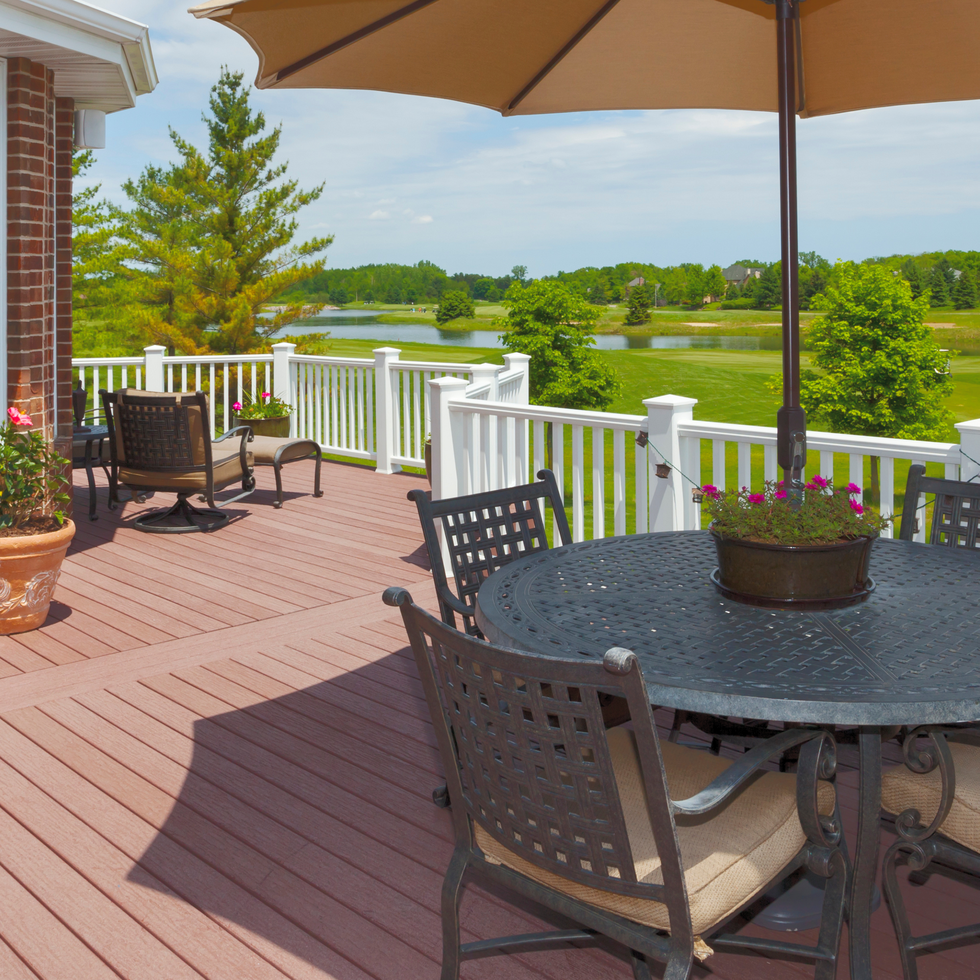 A deck with a table and chairs under an umbrella. Jarvis & Son Renovations,