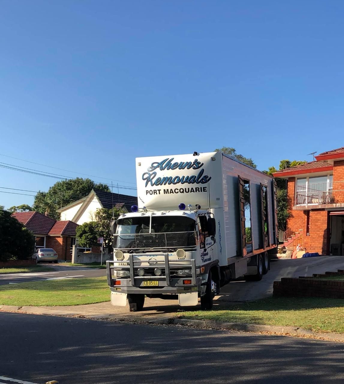 A Moving Truck Is Parked On The Side Of The Road — Ahern's Removals In Port Macquarie, NSW
