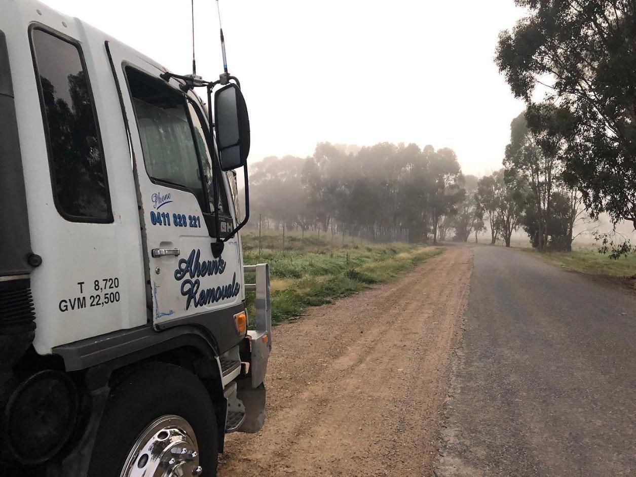 A White Truck Is Parked On The Side Of A Dirt Road — Ahern's Removals In Wauchope, NSW

